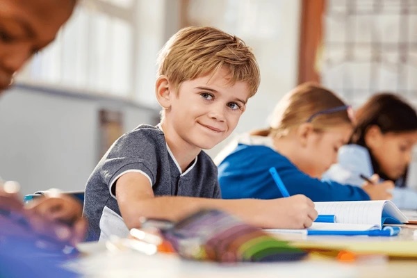 Student smiling while learning in classroom